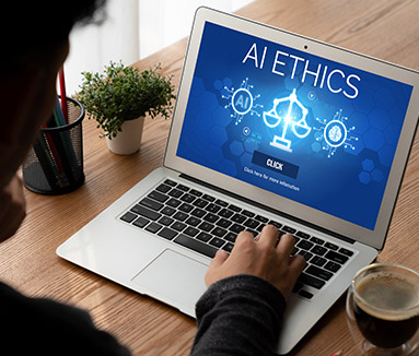 A person sitting in front of a computer screen that reads AI Ethics