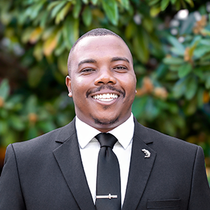 Headshot of smiling man in a dark suit