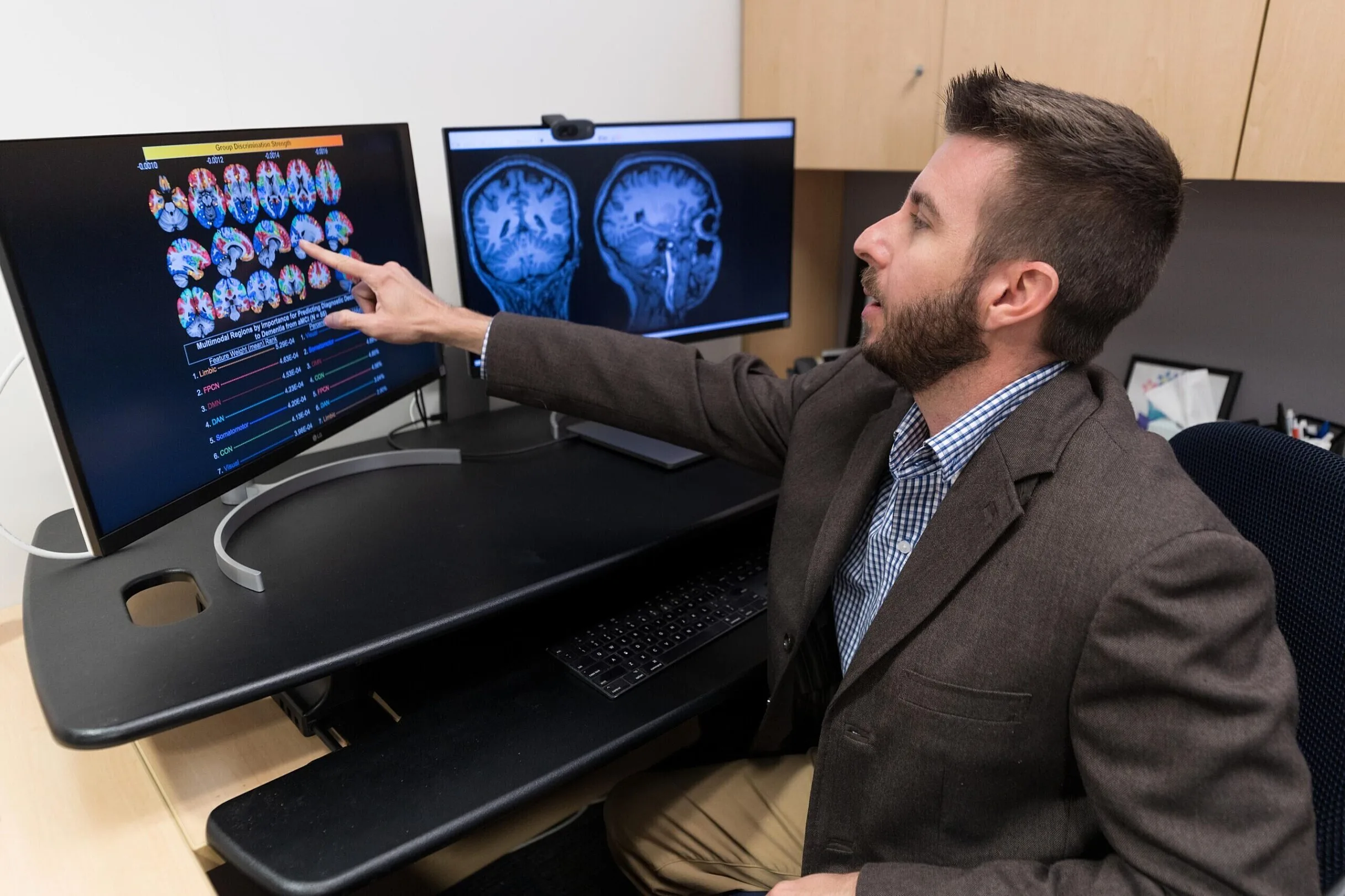 Man points to screen showing scans of a brain