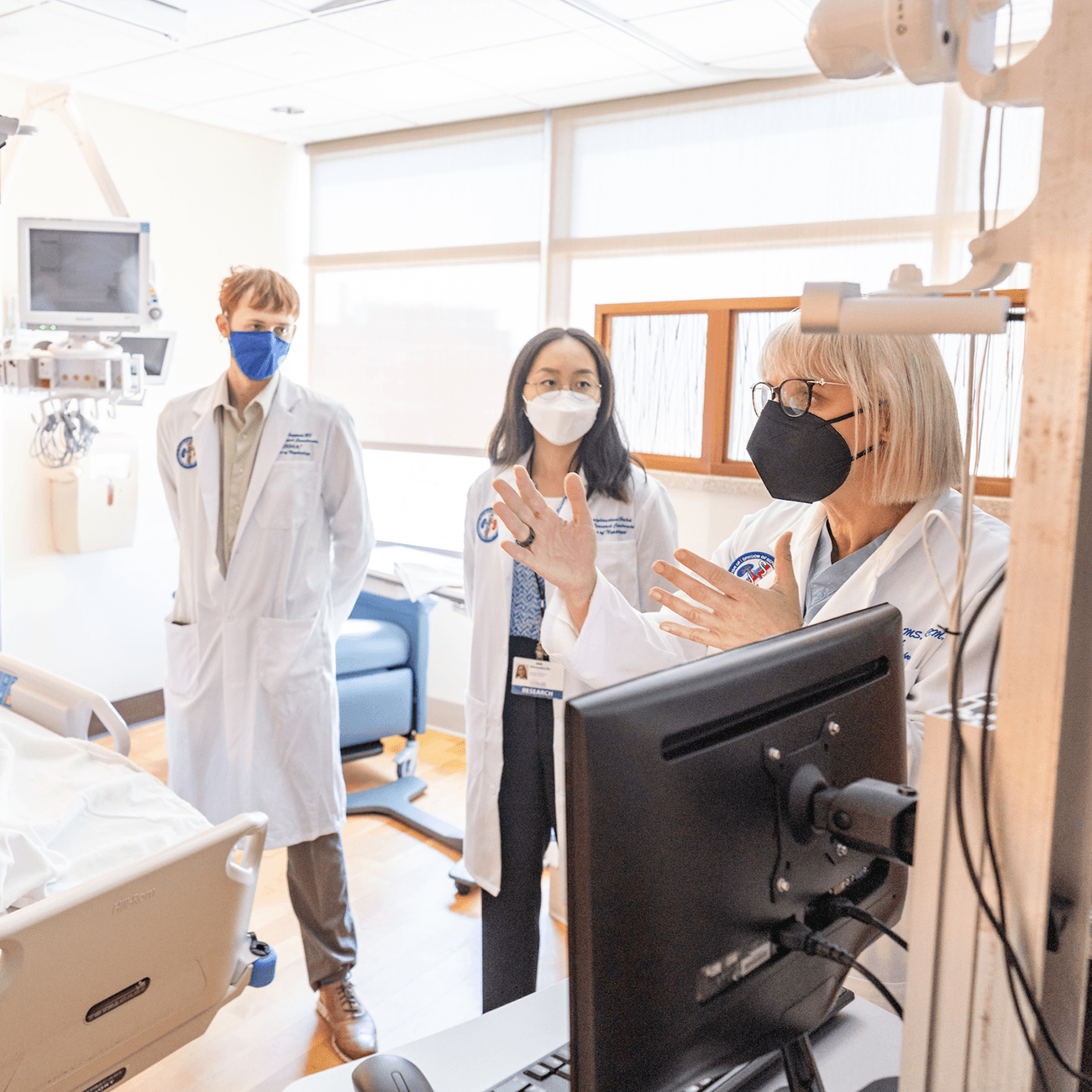 picture of medical care professor and students having conversation in the lab.