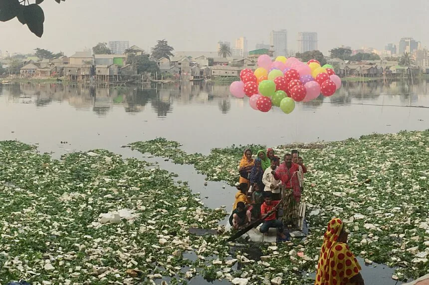 A group of people wade through an unsanitary body of water