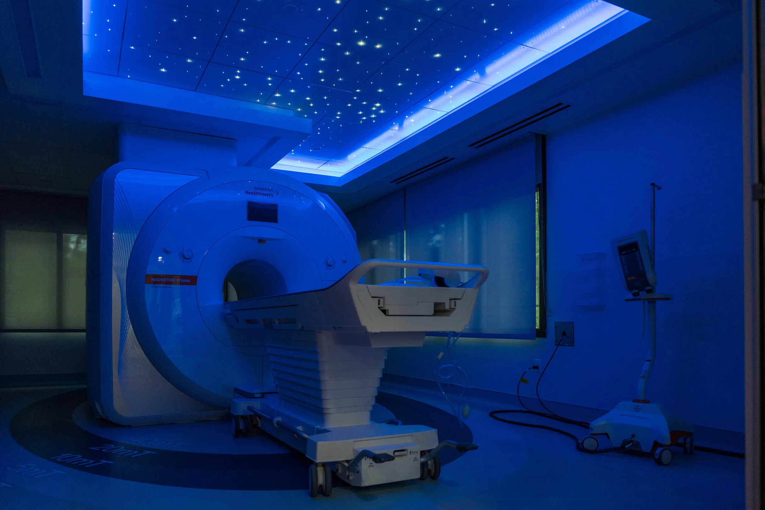 A neuroimaging machine in a dark blue lit room