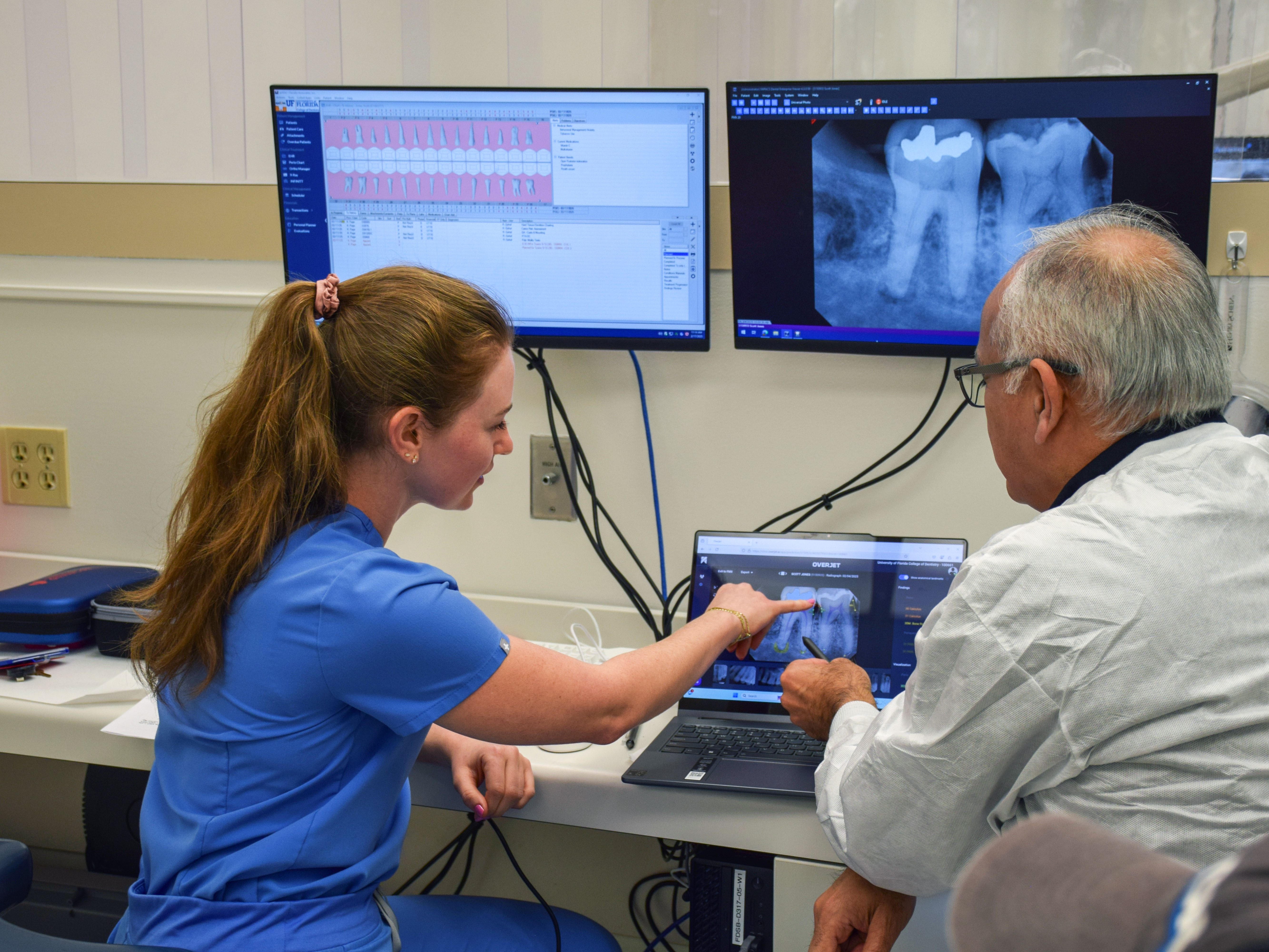 student looking at image of xray teeth on a computer