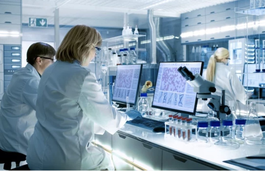 scientist looking into microscrope
