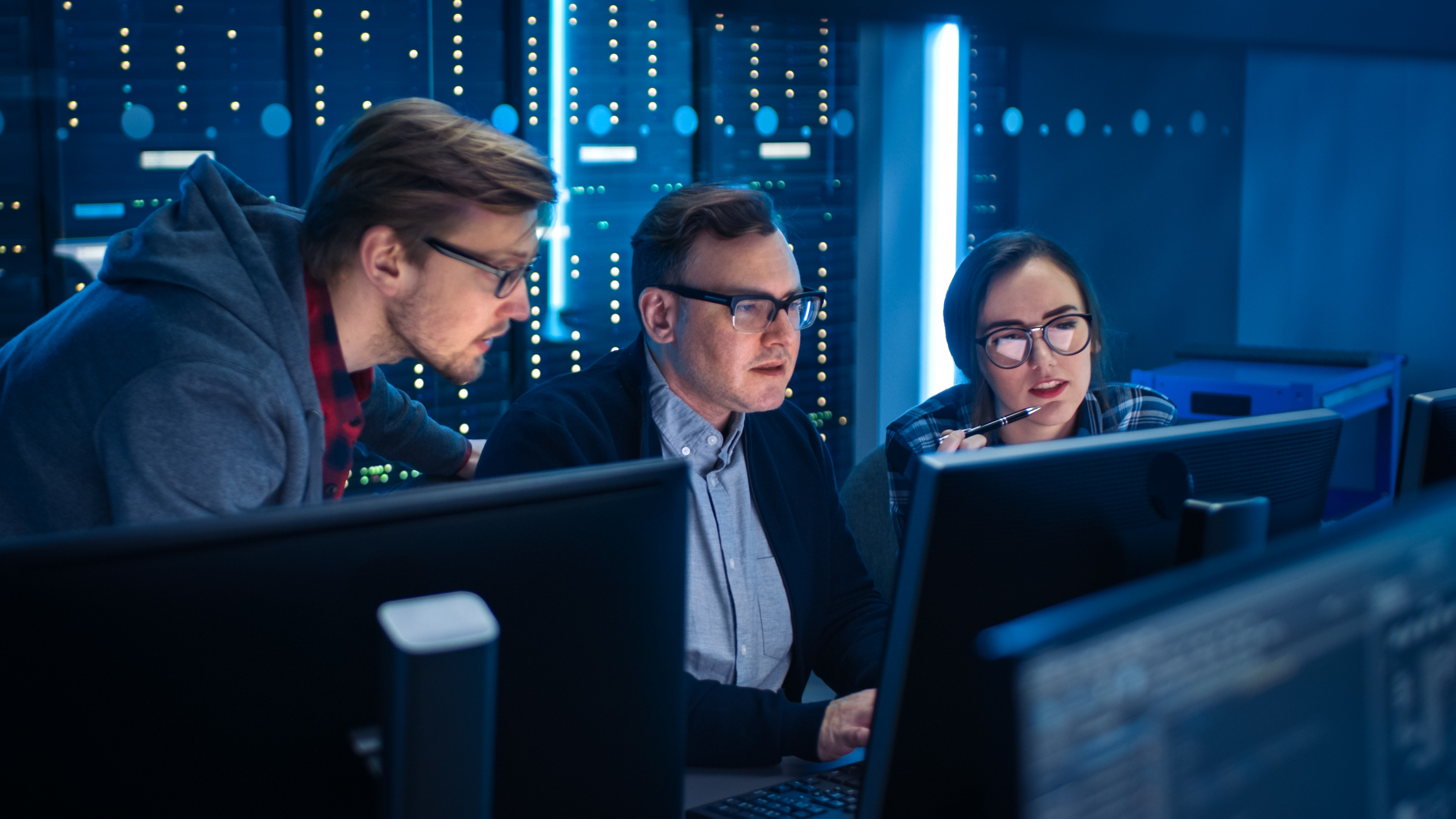 Three people are looking at information on a computer