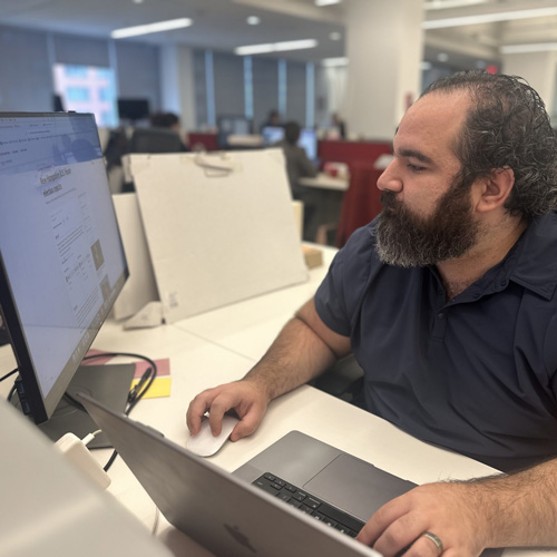 Andrew Briz works on his computer in a cubicle in POLITICO's newsroom.